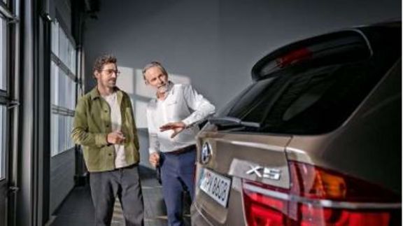 zwei Menschen in Werkhalle mit BMW