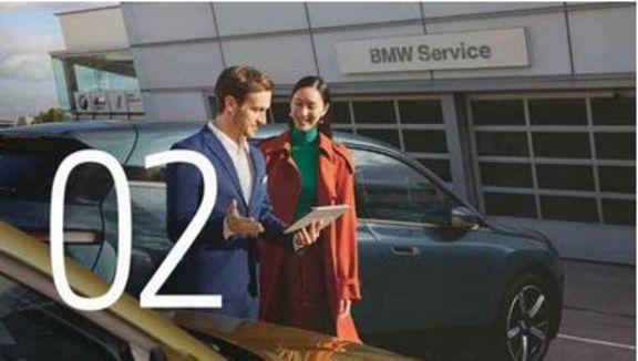 Symbolbild: Nr. 2: Zwei Menschen hinter BMW vor Servicewerkstatt