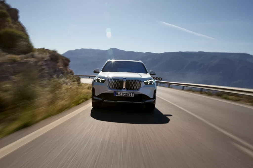 BMW iX1 von vorne auf Straße am fahren