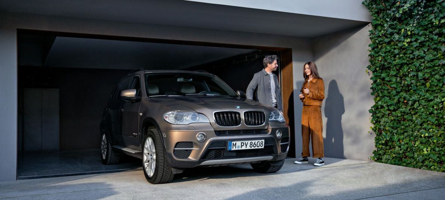 Paar neben BMW vor der Garage