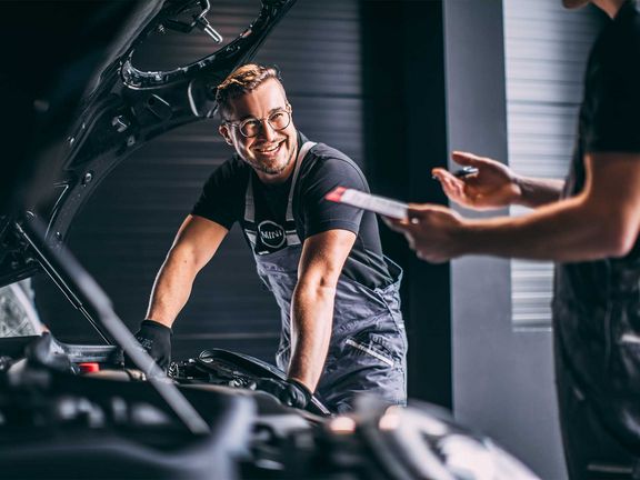 Mechaniker am Fahrzeug, lacht