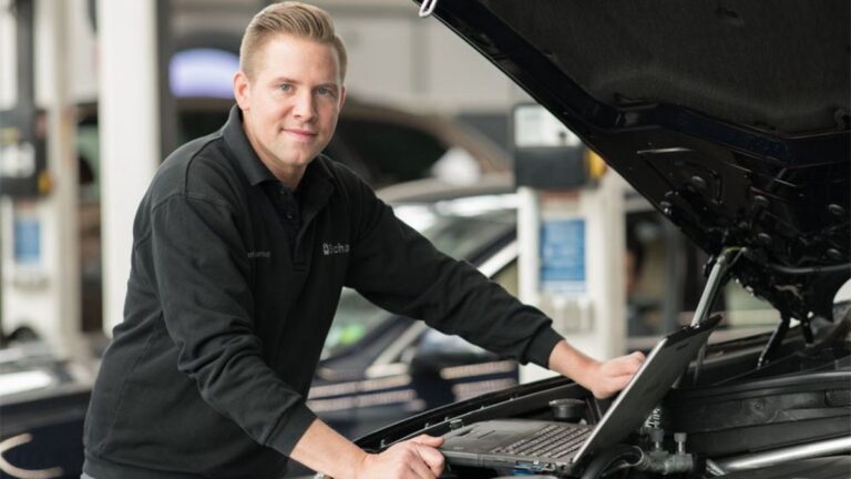 Mechaniker prüft Motor mittels Laptop