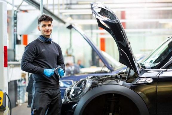 Mechaniker vor Mini mit geöffneter Motorklappe