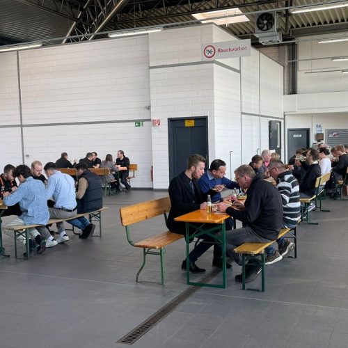 Mitarbeiter sitzen essend in Werkstatt