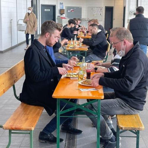 Mitarbeiter essen gemeinsam in Werkstatt